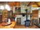 Inviting kitchen with stone fireplace and wooden cabinets, accented by copper pots and a charming wood-burning stove at 3317 S 100 E, Greenfield, IN 46140