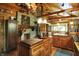 Open kitchen with a stone fireplace, wooden cabinetry, an island and copper pots in a warm, inviting space at 3317 S 100 E, Greenfield, IN 46140
