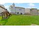 Expansive backyard featuring a lush lawn, wooden deck and two-story house, perfect for outdoor activities at 3362 Pavetto Ln, Indianapolis, IN 46203