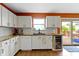 Well-lit kitchen features white cabinets, wood floors, and a view to an outdoor deck and backyard at 3362 Pavetto Ln, Indianapolis, IN 46203