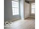A serene bedroom with two windows and a closet, with gray-blue walls and light wood floors at 352 W 28Th St, Indianapolis, IN 46208