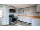 Well-lit kitchen featuring light-gray cabinetry, butcher block countertops, and stainless steel appliances at 352 W 28Th St, Indianapolis, IN 46208