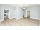 Open living room with light-toned flooring, neutral walls, white trim, and entryways into kitchen and hallway at 352 W 28Th St, Indianapolis, IN 46208