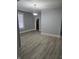 Open-concept living room with gray walls, wood-look flooring, bright window, and modern light fixture at 352 W 28Th St, Indianapolis, IN 46208