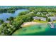 Scenic aerial view of a lakefront property with a sandy beach and clear water at 3532 Clearwater Cir, Indianapolis, IN 46240