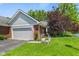 Well-maintained home exterior with brick accents, attached garage, and a beautifully landscaped front yard at 3532 Clearwater Cir, Indianapolis, IN 46240