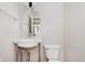 Bathroom features pedestal sink, oval mirror, and toilet at 355 E Ohio St # 209, Indianapolis, IN 46204