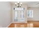 Dining area with wooden floors, chandelier, white walls, and a door that leads to a balcony at 355 E Ohio St # 209, Indianapolis, IN 46204