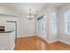 Dining area with wooden floors, chandelier, white walls, and a door that leads to a balcony at 355 E Ohio St # 209, Indianapolis, IN 46204