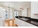Bright kitchen with stainless steel sink, black countertop, white cabinetry, and wooden floors at 355 E Ohio St # 209, Indianapolis, IN 46204