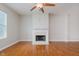 Living room with a white fireplace, wooden floors, and a ceiling fan at 355 E Ohio St # 209, Indianapolis, IN 46204