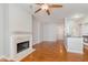 Open living room with hardwood floors, fireplace, ceiling fan, and kitchen access at 355 E Ohio St # 209, Indianapolis, IN 46204