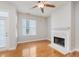 Spacious living room with fireplace, wooden floors, a ceiling fan, and a balcony at 355 E Ohio St # 209, Indianapolis, IN 46204
