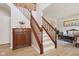 Elegant staircase with wood railing, complemented by light wood floors and tasteful decor at 4017 Ivory Ct, Carmel, IN 46074