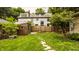 Secluded backyard with lush lawn, wooden fence, and stone walkway to detached shed at 4415 N Illinois St, Indianapolis, IN 46208