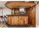 Unique knotty pine basement bar with barstool seating, storage shelves and a serving counter at 4415 N Illinois St, Indianapolis, IN 46208