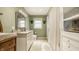 Well-lit bathroom featuring neutral tile, single vanity, and a shower with curtain, complemented by a linen cabinet at 4415 N Illinois St, Indianapolis, IN 46208