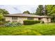 Charming single-story home with stone facade, lush green lawn, and well-manicured shrubs at 4415 N Illinois St, Indianapolis, IN 46208