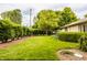 Well-kept front yard featuring green grass, mature trees, and neatly trimmed hedges at 4415 N Illinois St, Indianapolis, IN 46208