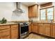 Well-lit kitchen equipped with stainless steel appliances, wooden cabinets, and a window for natural light at 4415 N Illinois St, Indianapolis, IN 46208