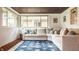 Sunroom with large windows, comfortable seating, and a patterned blue rug at 4415 N Illinois St, Indianapolis, IN 46208