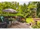 Outdoor seating with a striped umbrella overlooking a landscaped yard at 4428 Edinburgh Pt, Indianapolis, IN 46228