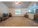 Bright living room featuring a ceiling fan, neutral walls, and large windows for natural light at 4428 Tucson Dr, Indianapolis, IN 46241