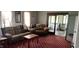 Comfortable living room boasting a large sofa, classic carpeting, and doorway to a separate sitting room with a fireplace at 4849 S 500 E, Greenfield, IN 46140