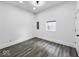 Bedroom featuring modern gray floors, white walls, and a single window with a view outside at 4923 E University Ave, Indianapolis, IN 46201
