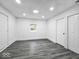 Bright bedroom with gray wood-look floors, white walls, and ample closet space at 4923 E University Ave, Indianapolis, IN 46201