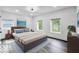 Sunlit bedroom with wood flooring, a wooden bed frame, and bright windows with outdoor views at 4923 E University Ave, Indianapolis, IN 46201