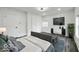 Cozy bedroom with a gray upholstered bed, accent rug, and a sleek modern entertainment center at 4923 E University Ave, Indianapolis, IN 46201