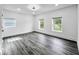 Bright bedroom with gray flooring, white walls and three windows that offer a view outside at 4923 E University Ave, Indianapolis, IN 46201