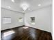Light-filled bedroom with hardwood floors, white walls, and modern chandelier at 4923 E University Ave, Indianapolis, IN 46201
