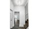 Bright entryway featuring a modern chandelier, wood-look floors, white trim and a staircase at 4923 E University Ave, Indianapolis, IN 46201