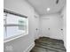 Bright hallway with three white doors, gray flooring, and a window with natural light at 4923 E University Ave, Indianapolis, IN 46201