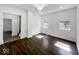 Sun-filled living room boasting dark wood floors, white walls, and a modern chandelier at 4923 E University Ave, Indianapolis, IN 46201
