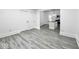 Open floor plan featuring light gray wood-look floors and white walls leading to kitchen at 4923 E University Ave, Indianapolis, IN 46201