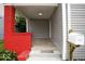 Inviting porch with bright red brick, wood-look tile, and a charming 'Home Sweet Home' doormat at 4923 E University Ave, Indianapolis, IN 46201