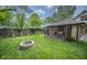 Landscaped backyard with a fire pit and screened porch for outdoor entertaining at 5024 N Kenwood Ave, Indianapolis, IN 46208