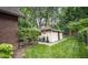 A serene backyard boasts a manicured lawn, a cozy outbuilding, and lush greenery, perfect for relaxing or entertaining guests at 5024 N Kenwood Ave, Indianapolis, IN 46208