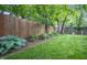 A spacious backyard featuring a lush lawn, mature trees, garden, and a charming wooden fence, creating a private outdoor oasis at 5024 N Kenwood Ave, Indianapolis, IN 46208
