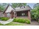 Classic Tudor-style home with a brick exterior, cozy porch, and well-maintained landscaping at 5024 N Kenwood Ave, Indianapolis, IN 46208