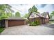 Two-car garage next to a brick home, surrounded by a gravel driveway and landscaping at 5024 N Kenwood Ave, Indianapolis, IN 46208