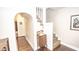 Hallway with hardwood floors, staircase, and view to the bathroom creating a comfortable and flowing floorplan at 5024 N Kenwood Ave, Indianapolis, IN 46208