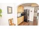 Small kitchenette with cabinets and shelving on a hardwood floor with views to another room through an archway at 5024 N Kenwood Ave, Indianapolis, IN 46208