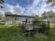 View of back yard with weathered wooden deck and siding, under a blue cloudy sky at 516 Memorial Dr, Edinburgh, IN 46124