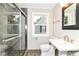 Modern bathroom with a glass enclosed shower, pedestal sink, and updated fixtures at 5884 Compton St, Indianapolis, IN 46220