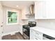 Kitchen featuring white cabinets, stainless steel appliances, and a black gas range at 5884 Compton St, Indianapolis, IN 46220