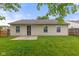 Backyard showcases a well-maintained lawn, the back of the house, and a wood fence at 6227 Long River Ln, Indianapolis, IN 46221